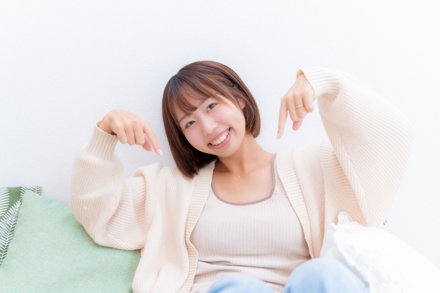 ffカールコスメは上がらない　指で下を差している女性